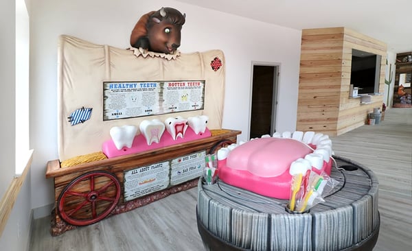 Western wagon themed educational area with tooth brushing station and cavity station.