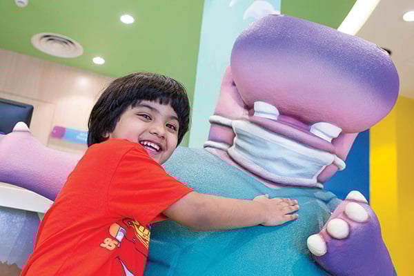 kid-hugging-clinic-mascot-sculpture